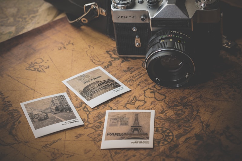 A vintage film camera resting on a wooden table beside a window in soft morning light.