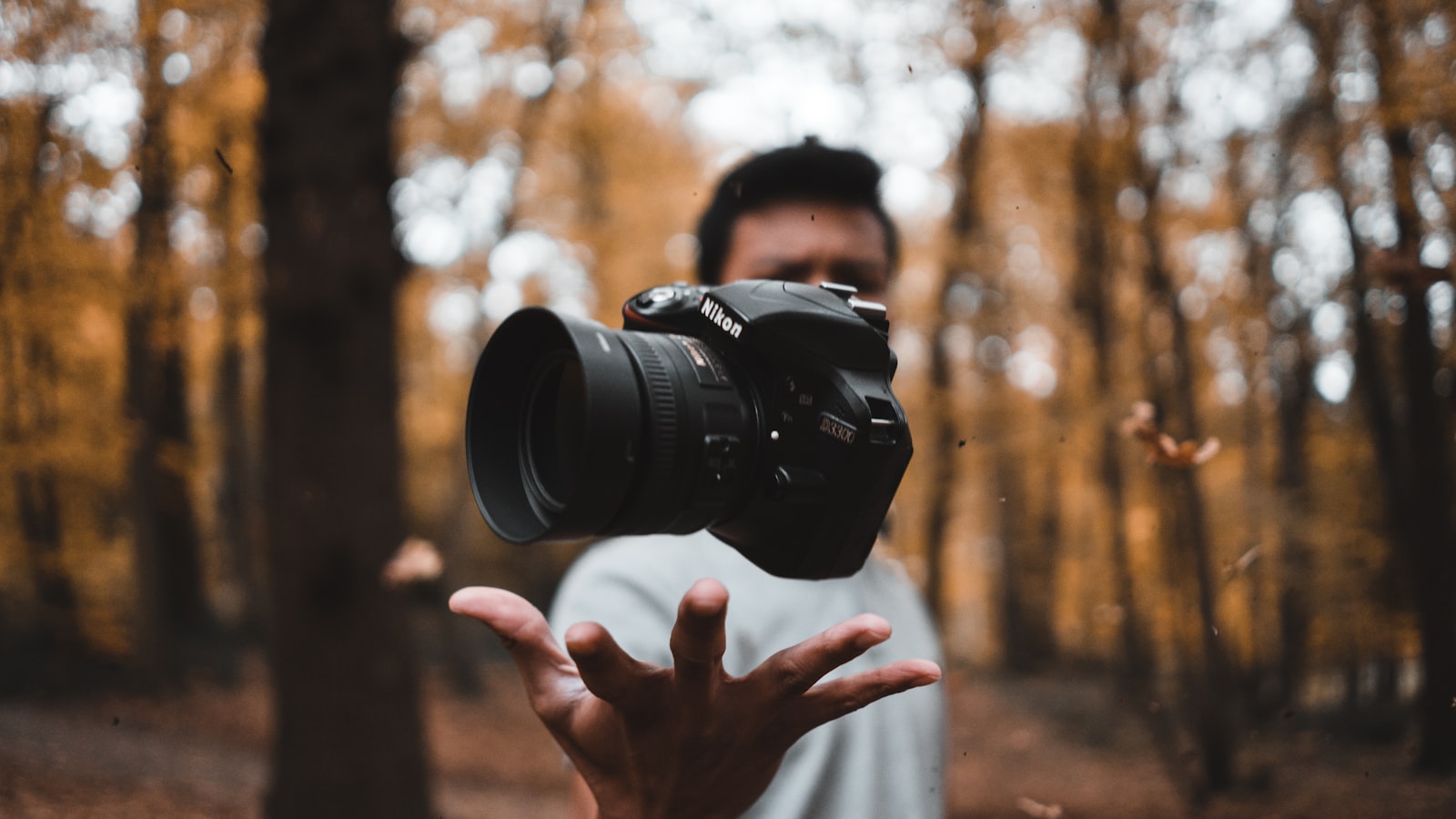 A photographer steadying a camera with both hands near a sunlit window